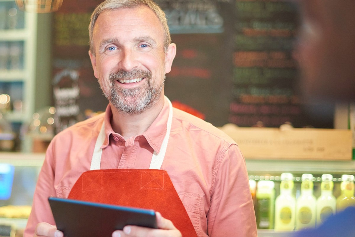 uptime-reliability Smiling cafe worker holding a tablet